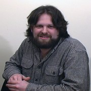 Smiling man with dark hair and facial hair